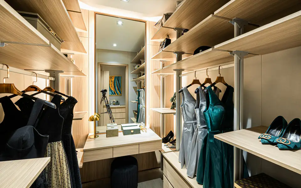 Lit walk-in wardrobe with mirror | Fitted wardrobes Newcastle Walk-in wardrobe with lit shelving, dresses and a full-length mirror, a fitted wardrobe idea for Newcastle homes
